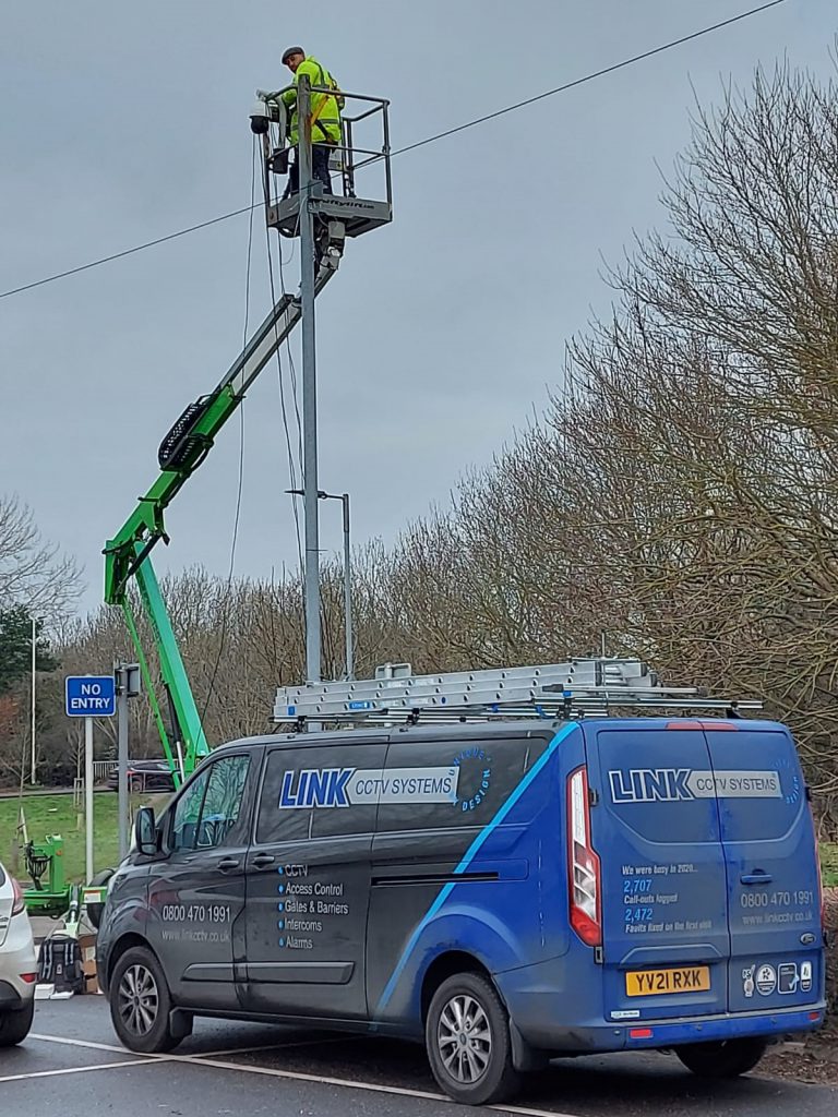 Liam Valentine on a cherry picker in front of a Link CCTV Systems van in Chelmsford, Essex.