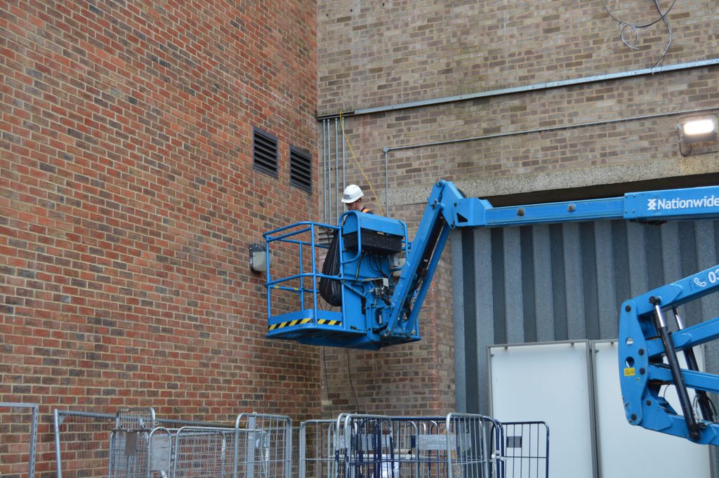 A Link engineer working on a cherry picker.